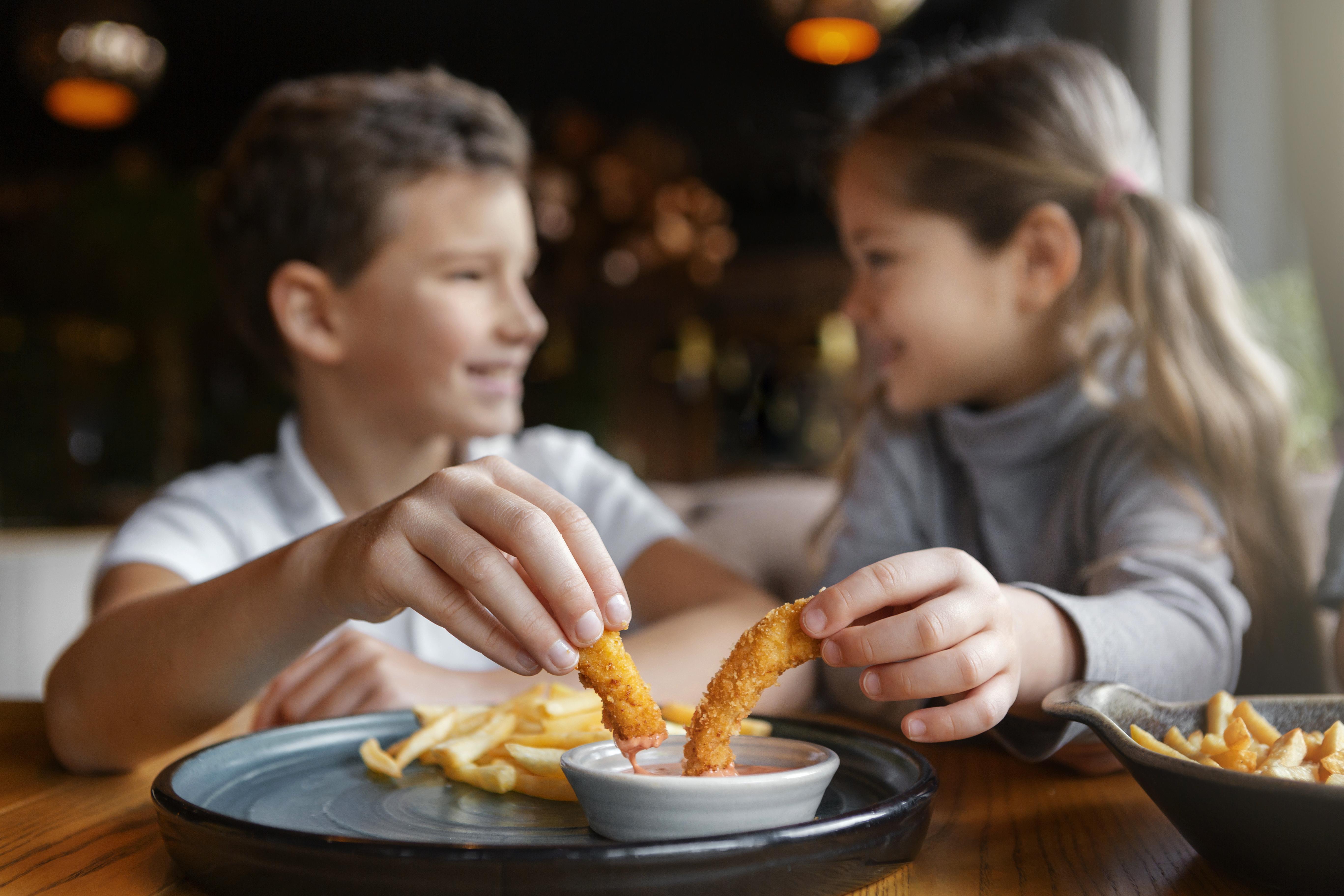 medium shot smiley kids eating together